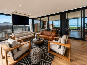 Furnished living room at House 671 with large sliding glass doors opening to the balcony