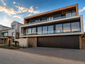 Completed street view of House 671 showing the double garage, glazed balcony and timber soffit