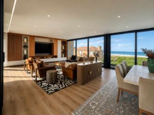 Open-plan kitchen, dining and living area at House 671 with timber finishes and ocean views