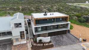 Aerial front view of completed House 671 in Stilbaai and its coastal hillside setting