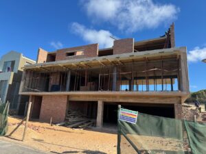 House 671 construction progress with scaffolding across the front elevation