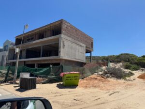 Early construction stage of House 671 showing exposed concrete floor slabs and structural walls