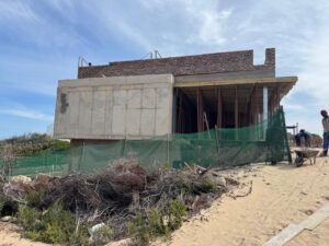 Rear construction view of House 671 with concrete walls and the upper structure in progress