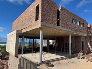 House 671 during construction with unfinished upper brick walls above the concrete ground floor