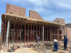 Construction workers installing formwork and supports for the upper level of House 671